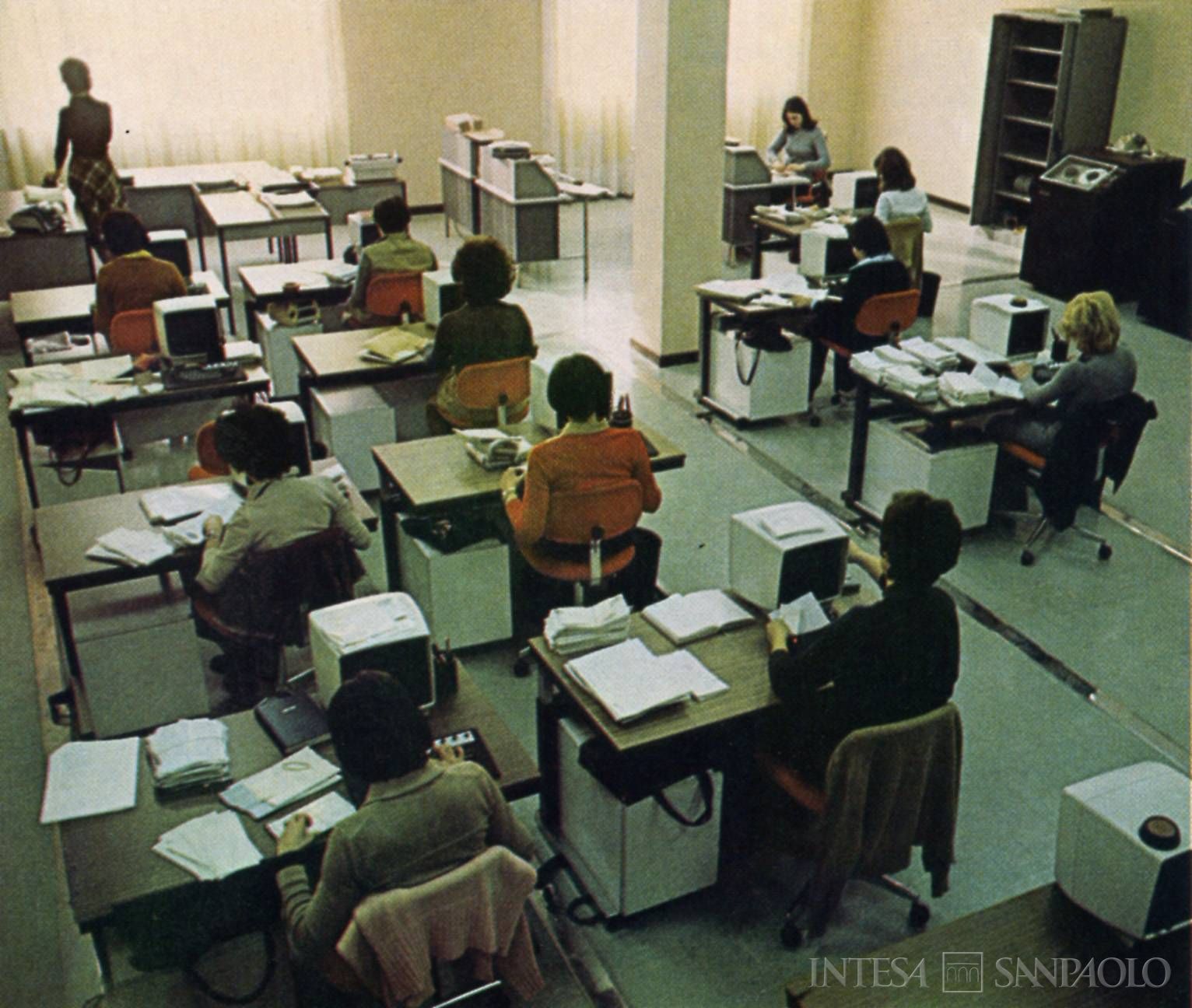 Banco Lariano, impiegati di retrosportello, fotografia tratta da un opuscolo informativo edito dall'istituto, 1975 (fotografo sconosciuto)