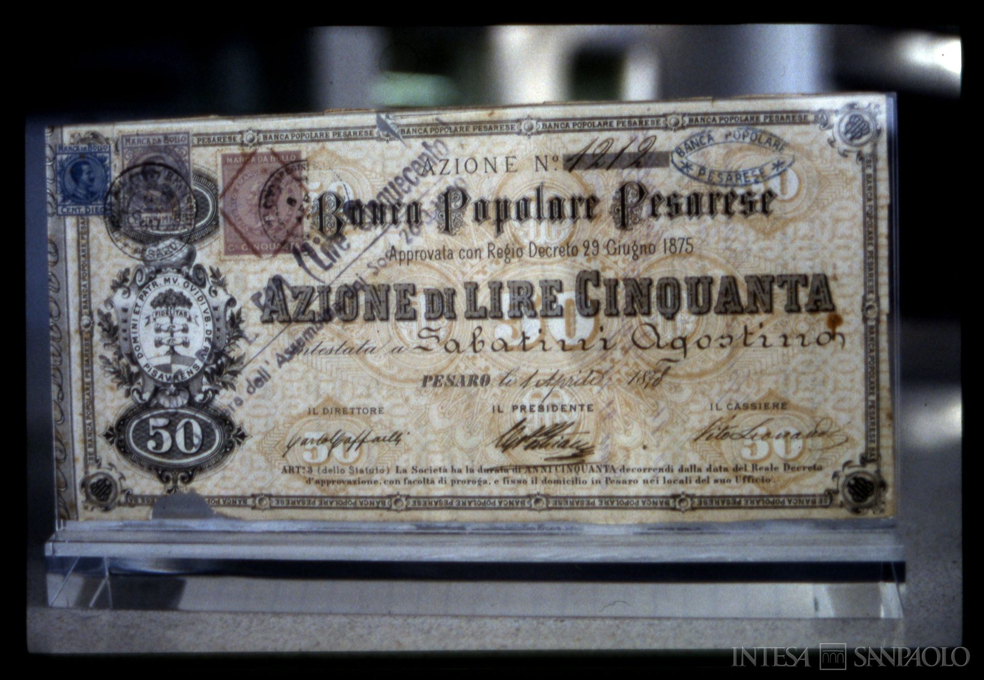 Banca Popolare Pesarese, certificato azionario datato 1 aprile 1878, esposto nella sede, anni Ottanta (fotografo sconosciuto)