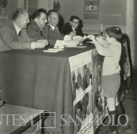 Cassa di Risparmio di Città di Castello, premiazione di un bambino durante la Giornata Mondiale del Risparmio del 1966, fotografia tratta da Il Bollettino del Risparmio, n. 11, 1966 (fotografo sconosciuto)