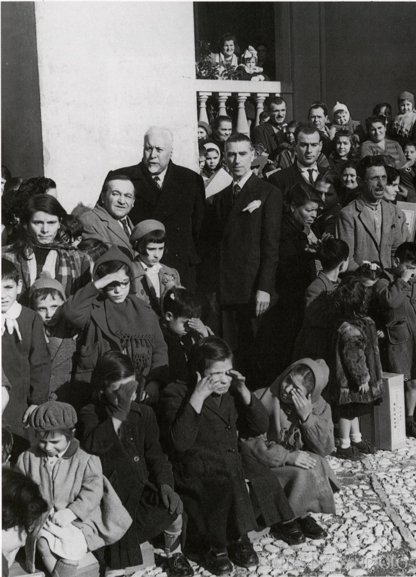 Cassa di Risparmio di Rieti, il presidente Amedeo Liberatila tra i bambini per la Befana dell'istituto, 1950, fotografia tratta da Cassa di Risparmio di Rieti. 150° della fondazione, 1996 (fotografo sconosciuto)