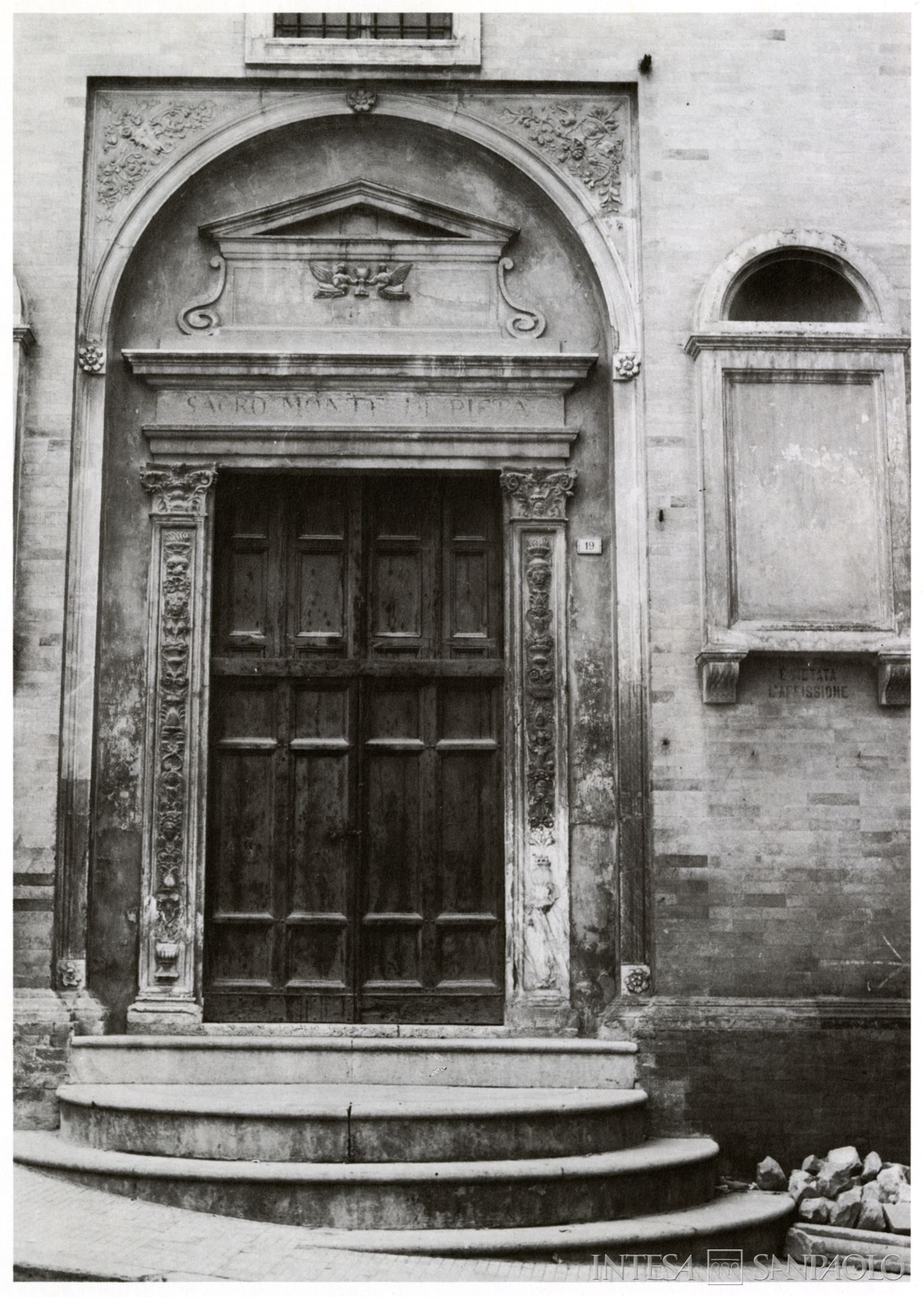 Monte di Credito su Pegno di San Severino, Portone della sede storica, fotografia tratta da Archivio Storico Intesa Sanpaolo, Sezione Bibliografica, Dante Cecchi, Macerata e il suo territorio: la storia, Cassa di Risparmio della Provincia di Macerata, 1979, p. 156